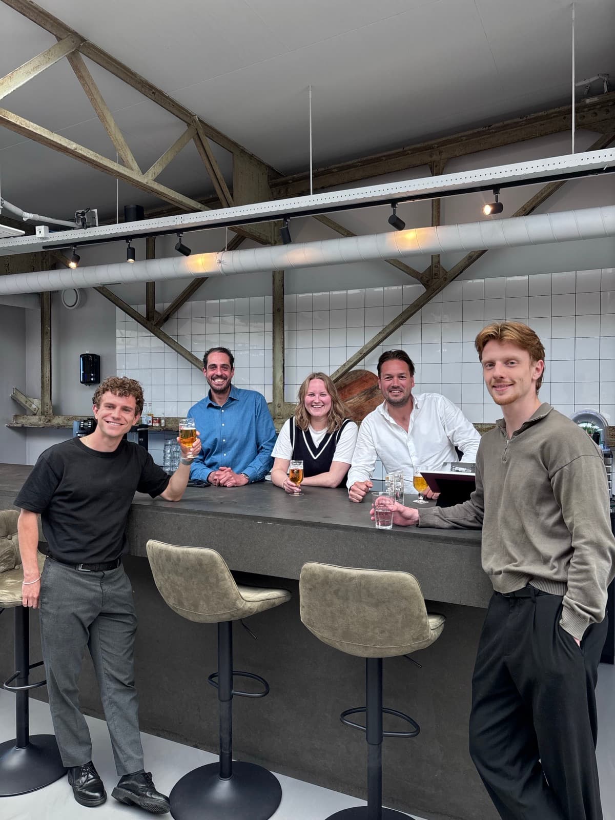 Collega's van Search X kletsen aan de bar tijdens een borrel